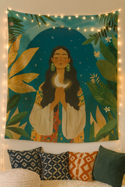 Cosmic Queen boho wall tapestry with a celestial woman illustration with moon in her hand and stars hanging above a bed in a cosy boho bedroom